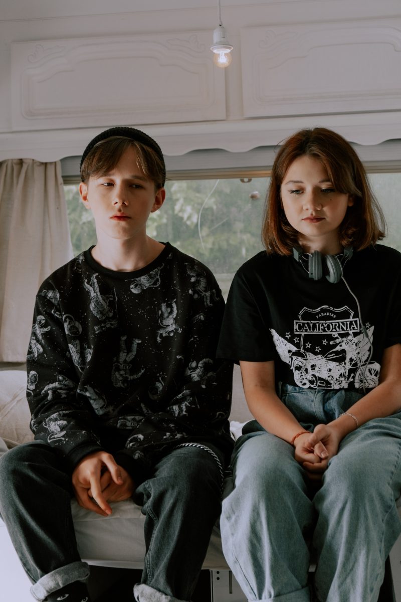 A boy and a girl sit next to each other awkwardly